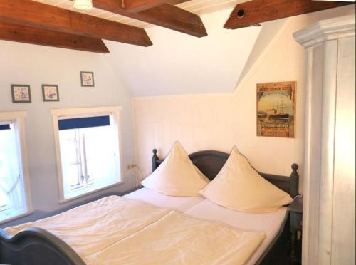 SüddorfにあるHüs Sanskiin Ferienwohnung *Driiwholt*のベッドルーム1室(白いシーツと枕のベッド1台付)