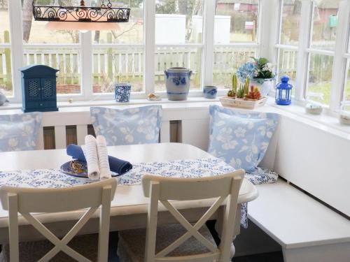 a dining room with a table and chairs and windows at Hüs Sanskiin Ferienwohnung *Brombelbei* in Süddorf