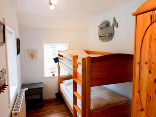 a bedroom with two bunk beds and a window at Hüs Sanskiin Ferienwohnung *Hopelfask* in Süddorf