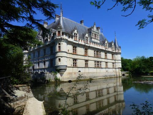 a large building sitting on top of a river at Hôtel de Biencourt in Azay-le-Rideau