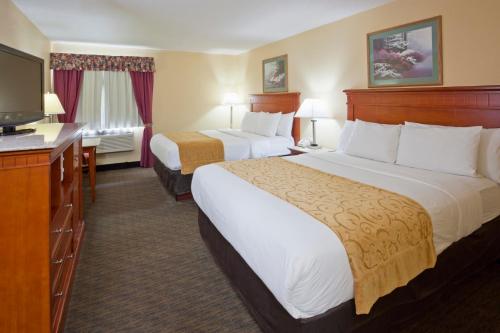 a hotel room with two beds and a flat screen tv at GrandStay Hotel and Suite Waseca in Waseca