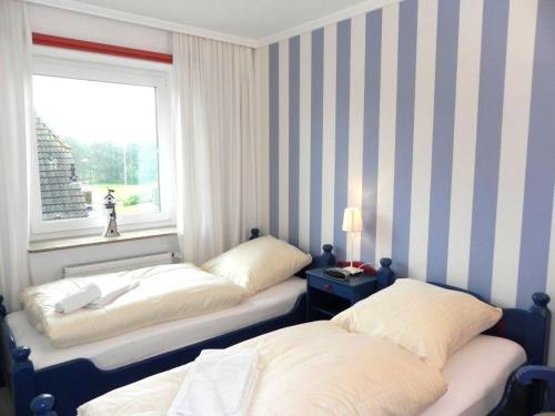 two beds in a room with a window at Ferienwohnung *Jessen´s Wattblick* in Wittdün