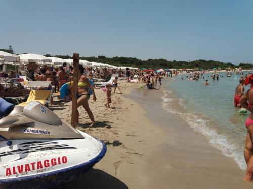 a crowd of people on a beach with a boat at Appartamento Paola marina di Ostuni in Villanova di Ostuni