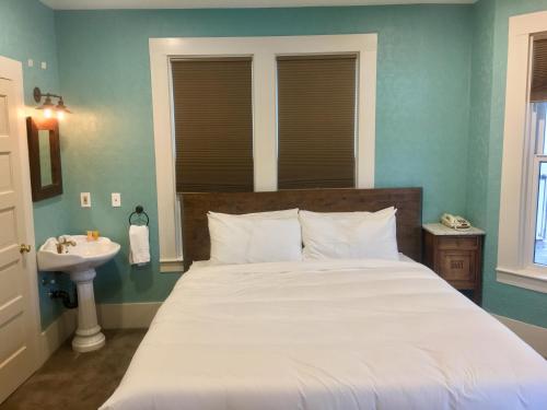 a bedroom with a large bed and a sink at The Groveland Hotel in Groveland