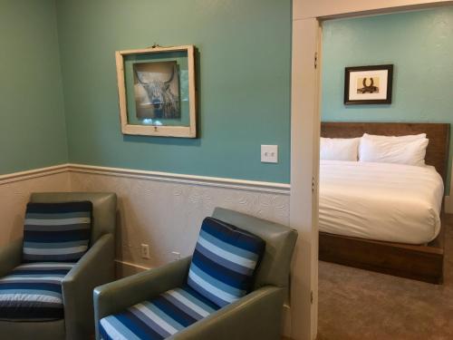 a hotel room with a bed and two chairs at The Groveland Hotel in Groveland