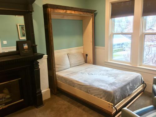 a small bed in a room with a fireplace at The Groveland Hotel in Groveland
