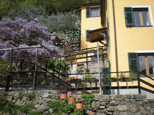 ein Gebäude mit lila Blumen und einer Steinmauer in der Unterkunft Agriturismo Il Sogno in Lorsica