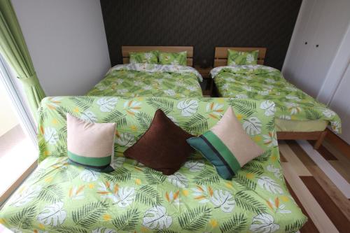 2 łóżka z poduszkami w pokoju w obiekcie guesthouse yu -SEVEN Hotels and Resorts- w mieście Yomitan