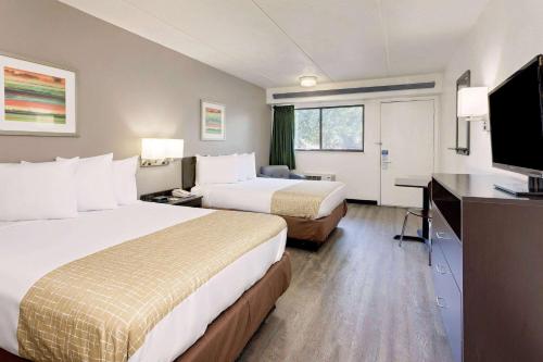 ein Hotelzimmer mit 2 Betten und einem Flachbild-TV in der Unterkunft Travelodge by Wyndham College Park in Atlanta