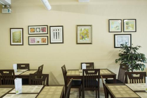 ein Esszimmer mit Tischen, Stühlen und Bildern an der Wand in der Unterkunft GV Hotel - Valencia in Valencia