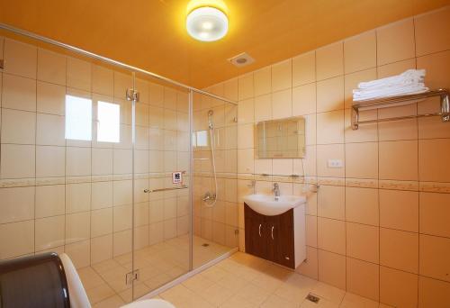 a bathroom with a glass shower and a sink at Sea of Clouds Vacation Villa in Renai
