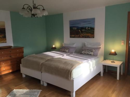 a bedroom with a bed and a dresser with two lamps at Historical Apartment in Gummersbach