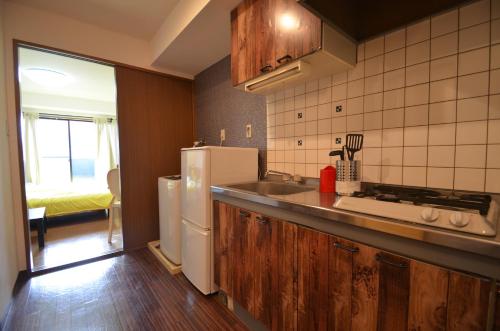 a kitchen with a sink and a refrigerator at Apartment Zen Hotel in Mizuho