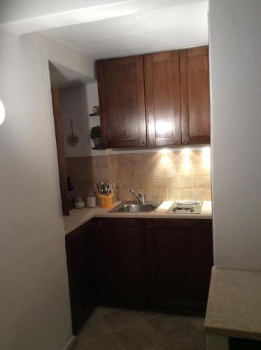 a kitchen with wooden cabinets and a sink at Old castle S. Croce in Cagliari