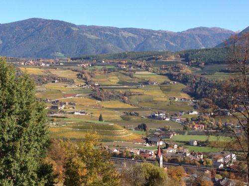 a small town in a valley with mountains in the background at BUEHLERHOF Agriturismo, Obst-&Weingut, Urlaub mit Hund, Bauernhof, Brixen in Rosa