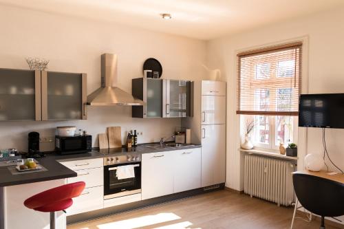 a kitchen with white appliances and a red stool at Loft Apartment Limburg in Limburg an der Lahn
