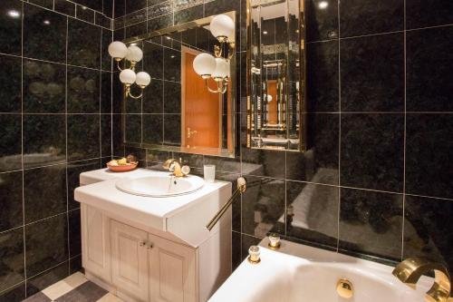 une salle de bain avec un lavabo, une baignoire et un miroir dans l'établissement Dairy Cottage, à Ayr