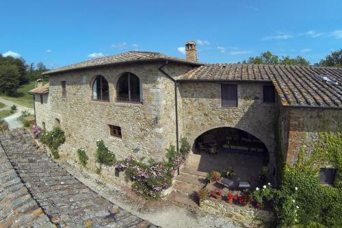 a large stone building with flowers on the side of it at Castellare in Chiusdino