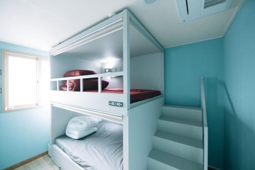 a small room with a bunk bed and stairs at Daegu Midtown Hostel in Daegu