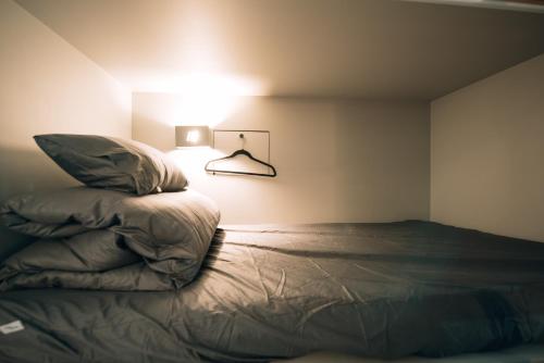 a bedroom with a bed with a lamp next to it at Daegu Midtown Hostel in Daegu