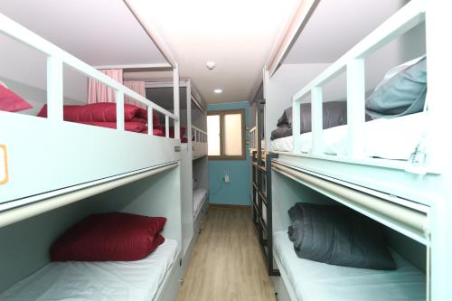 a room with four bunk beds with red pillows at Daegu Midtown Hostel in Daegu