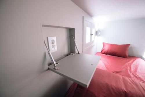 a bedroom with a red bed and a table at Daegu Midtown Hostel in Daegu