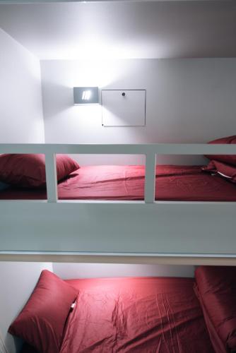 a bedroom with a bed with red pillows at Daegu Midtown Hostel in Daegu