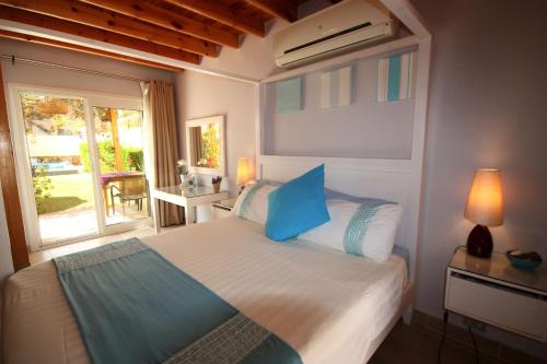a bedroom with a bed with blue pillows and a window at Deluxe Seahorse Apartment - Lagoon Villa in Dahab