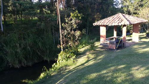 a gazebo in the grass next to a river at Apartamento Acogedor en el Retiro in El Retiro