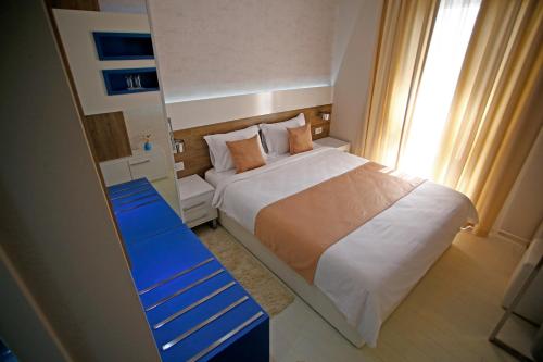 a small bedroom with a bed and a blue bench at Rox in Modriča