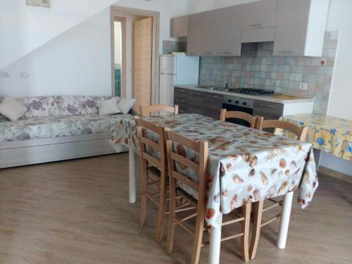 a kitchen with a table and chairs and a couch at Appartamenti Santa Teresa Gallura in Santa Teresa Gallura