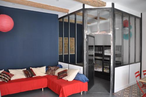 Habitación con 2 camas rojas y pared azul. en Rouge Pompon, en Mèze