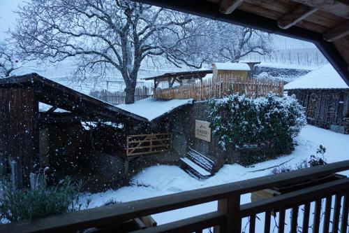 a yard covered in snow with a house at BUEHLERHOF Agriturismo, Obst-&Weingut, Urlaub mit Hund, Bauernhof, Brixen in Rosa