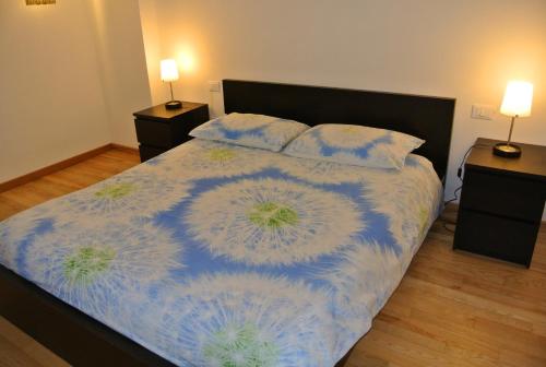 Schlafzimmer mit einem Bett mit einer blauen und weißen Bettdecke in der Unterkunft Agriturismo Domus Magna in Povoletto