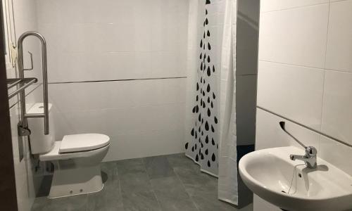 a white bathroom with a toilet and a sink at Mirador Tierra de Frontera in Alcalá la Real