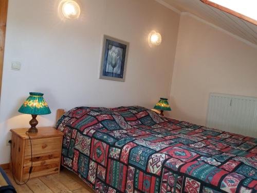 a bedroom with a bed and two lamps on a night stand at Aux 4 chalets in Bouillon