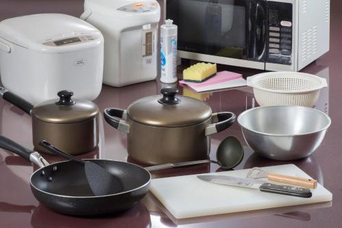 a counter top with pots and pans and a microwave at Izumigo AMBIENT Azumino Cottage in Azumino
