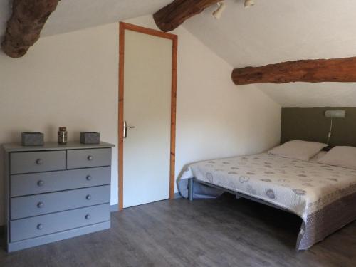 a bedroom with a bed and a dresser at La Nichoule in Rosières