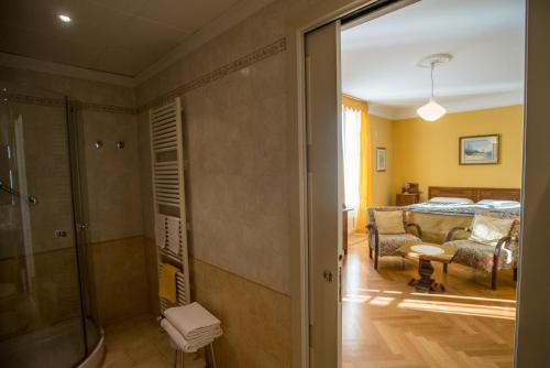 a bathroom with a shower and a bedroom at Hotel Olivedo in Varenna