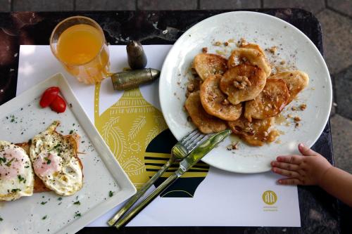 a table with a plate of food and a glass of orange juice at Hotel Archontiko Anyfanti in Zátouna