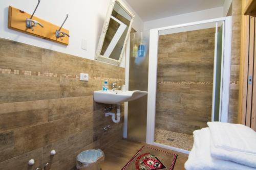 uma casa de banho com um lavatório e um chuveiro em Olimpic Hostel em Schilpario