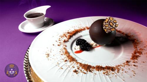 a plate with a chocolate doughnut and a cup of coffee at Logis Domaine des Chais in Thénac