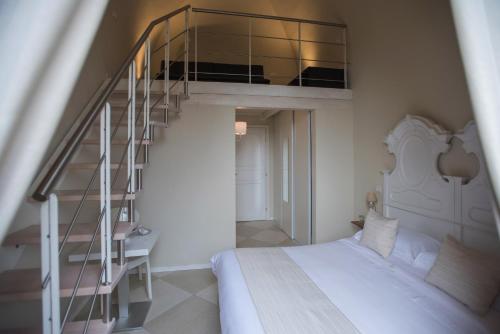 a bedroom with a bed and a spiral staircase at Palazzo Belsanti in Lecce