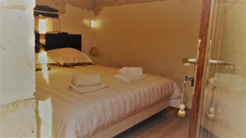 a bedroom with a bed with two towels on it at Le gîte des chambres de la grange in Cherval