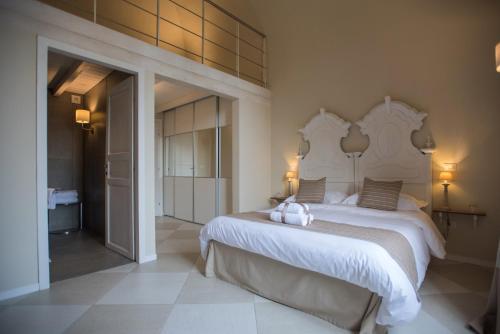 1 dormitorio con 1 cama blanca grande con 2 animales de peluche en Palazzo Belsanti, en Lecce