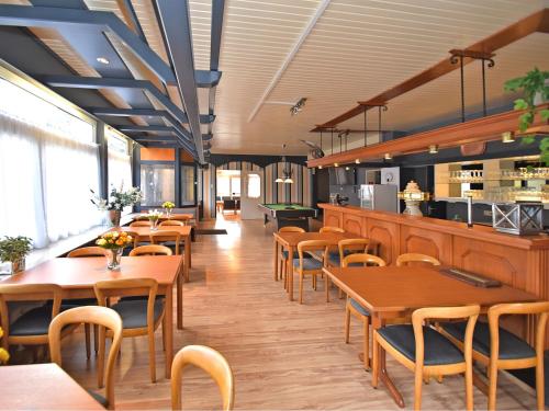 a restaurant with wooden tables and chairs and a counter at Spacious Holiday Home in L wensen Lower Saxony near Forest in Löwensen