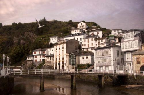 a bridge over a river with houses on a hill at Casa Del Beso in Luarca