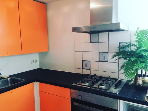 a kitchen with orange cabinets and a stove top oven at SOEPP hotel & restaurant in Alkmaar