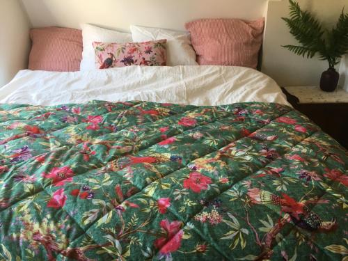 a bed with a green blanket with flowers on it at SOEPP hotel & restaurant in Alkmaar