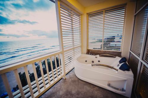 a bath tub in a balcony with a view of the ocean at Beacon Beach Hotel Negombo in Negombo